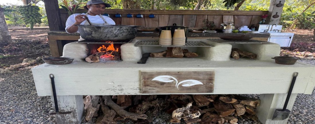 An open fire kitchen under a timber roof