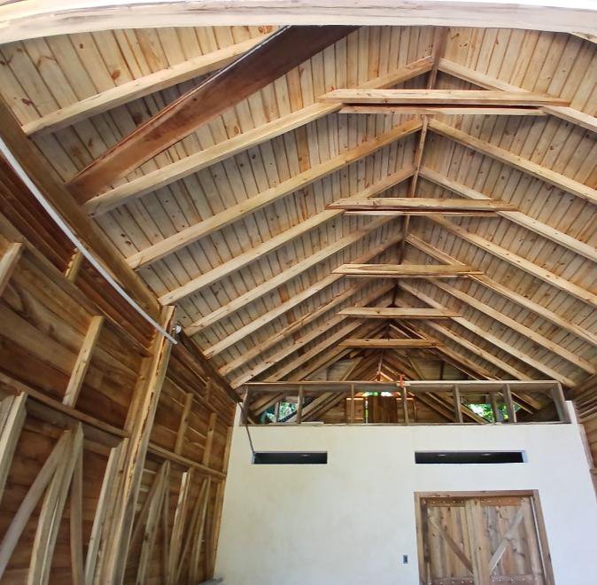 An exposed timber roof structure from inside