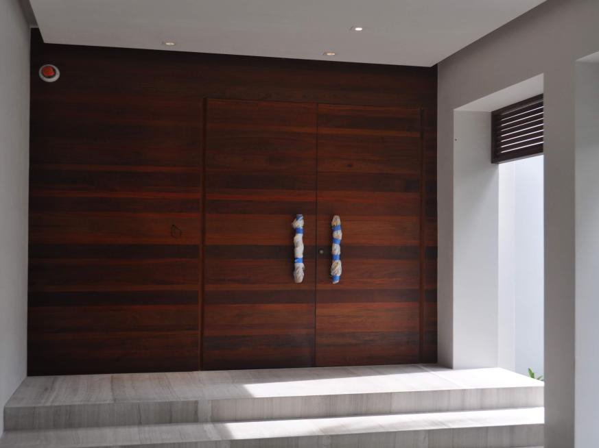A tall hardwood entrance door